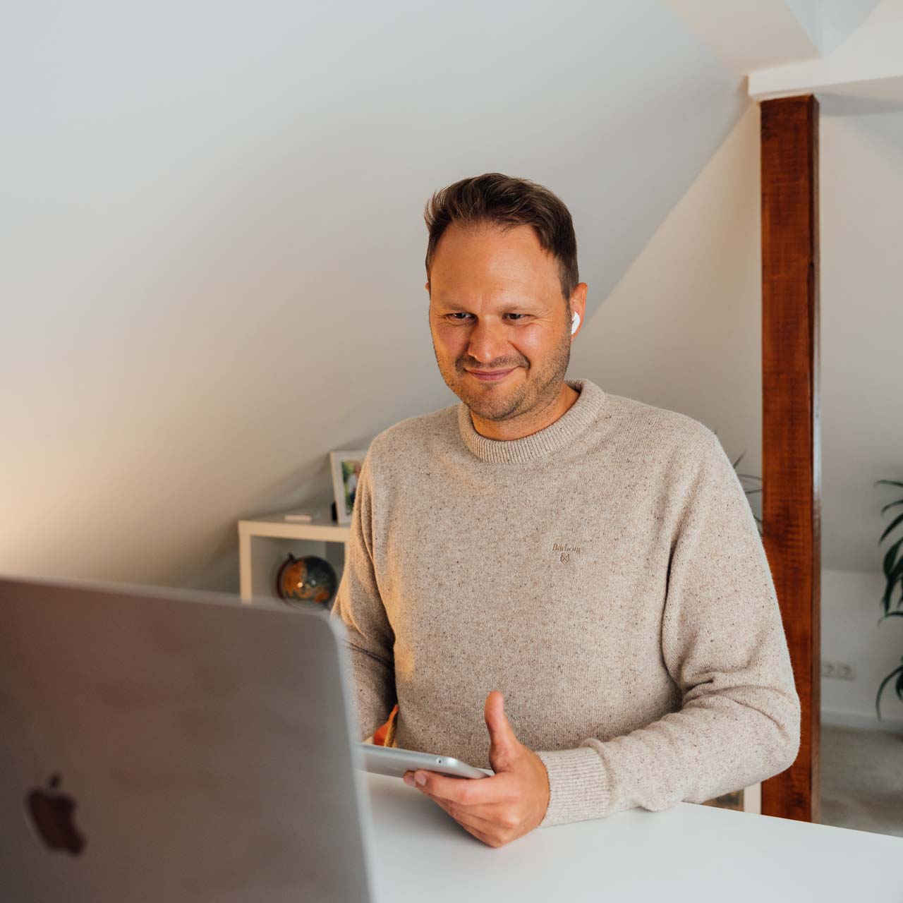 Authentisches Personal Branding Fotoshooting in Pinneberg: Carsten Ewering bei der Arbeit am Laptop in heller Büro-Atmosphäre, fotografiert von Henning von Holdt